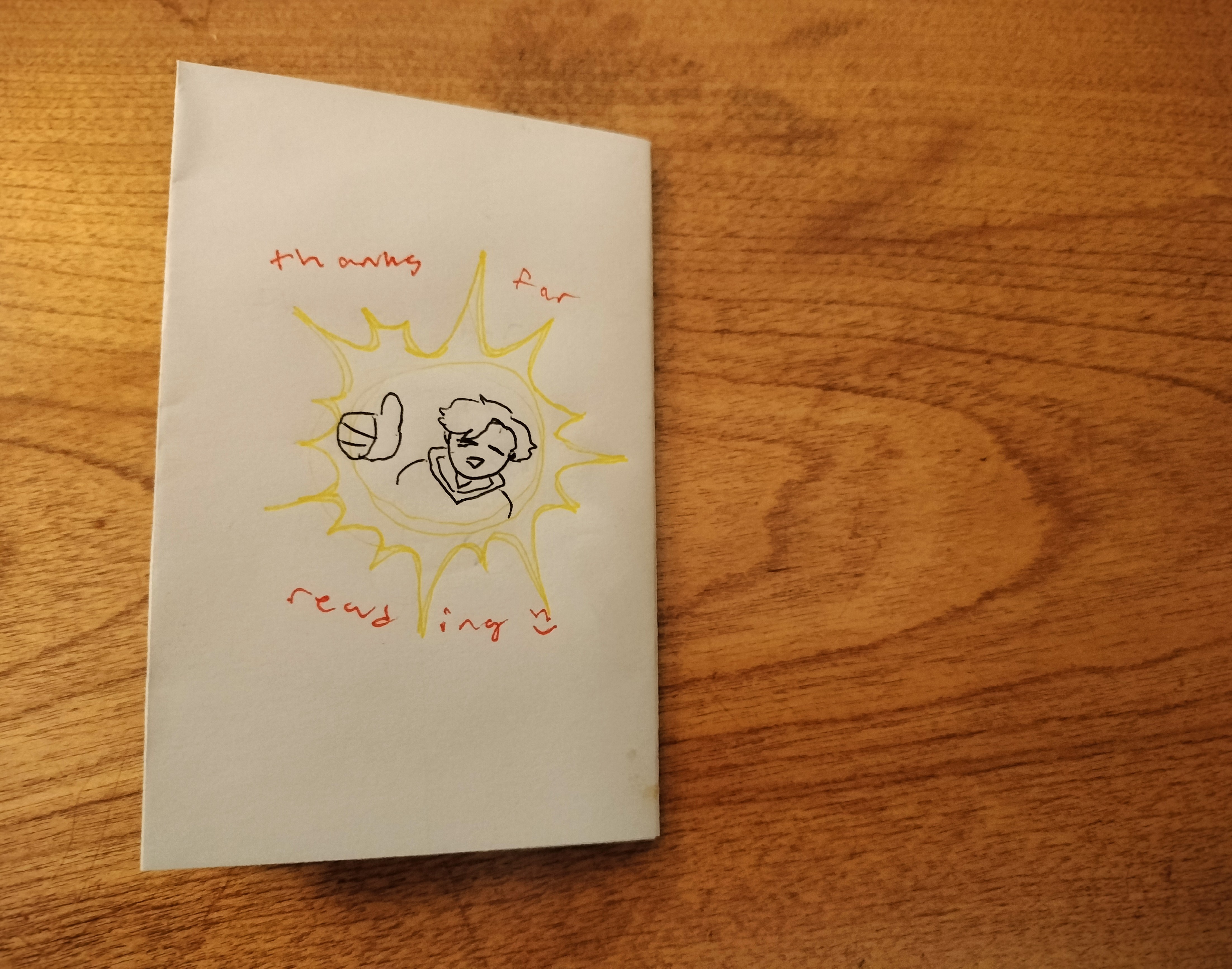 The back cover of the zine. A simplified shoulders-up of OP smiles and gives a comically big thumbs up, with the words- thanks for reading- written in red, plus another smiley face emoticon. The thumbs up is surrounded by a halo of yellow light, for emphasis.